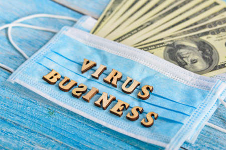 The concept of earning on a coronavirus. Protective mask and dollars.の写真素材