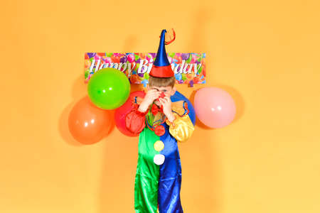 A clown with balls puts on a red nose.の写真素材