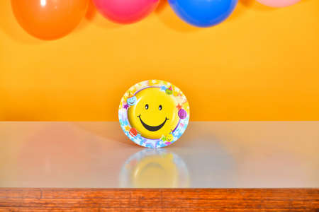 A yellow plate with a big smile is on the table.の写真素材