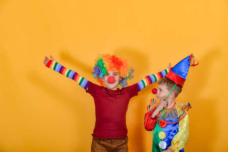 Two clowns hug and wave their arms around.