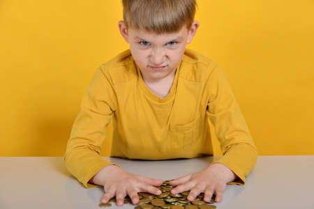 The child took all the coins for himself and does not want to share with anyone.の写真素材
