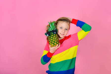 The girl in the striped sweater laid a pineapple on her shoulder.