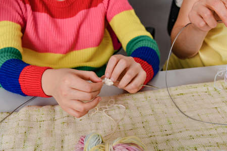 Mom teaches her daughter how to knit.