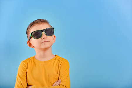 A boy with a big smile and glasses looks up.の写真素材