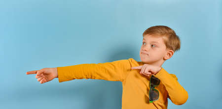 The boy with glasses extended a finger on both hands to the side.