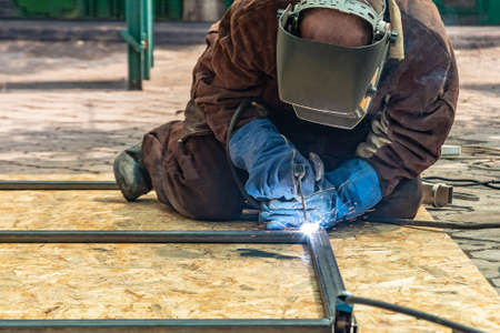 An electric welder assembles a metal structure from a shaped pipe by welding with an electrode.