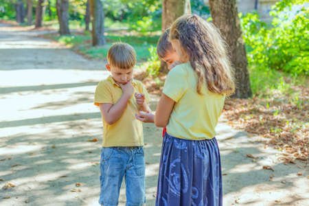 Children hold a compass in their hand and do not know where to go, hiking and tourism concept.の写真素材