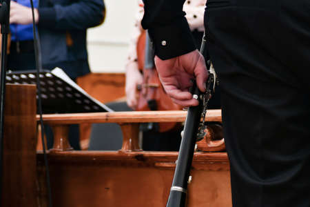 A man holds a clarinet in his hand before performing at a concert.の写真素材