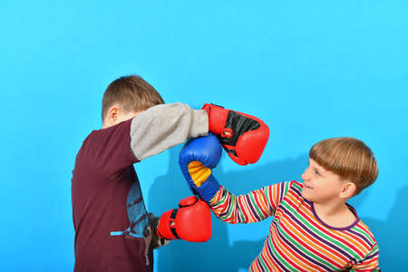 Two young boxers are fighting in boxing gloves in the studio on a blue background.の写真素材