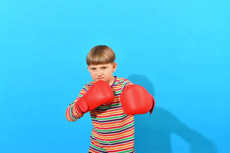 A boy in red boxing gloves makes an attacker punch.の写真素材