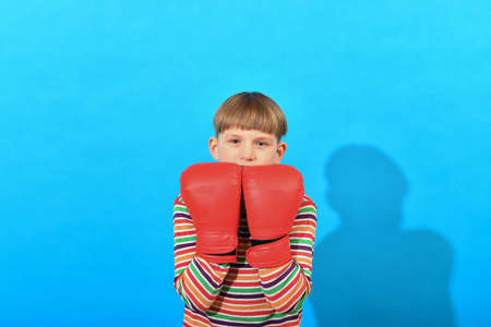 A small boxer in red boxing gloves holds them in front of him with bent elbows.の写真素材