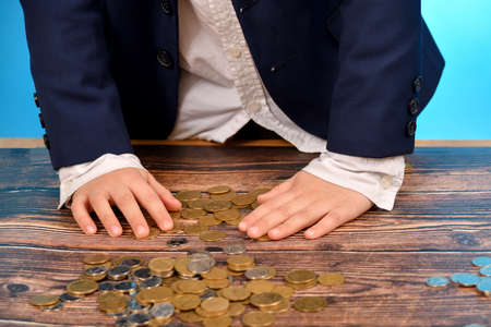 A boy in a blue suit is counting money.の写真素材