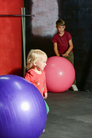 Children play with a fitness ball in the gym.の写真素材
