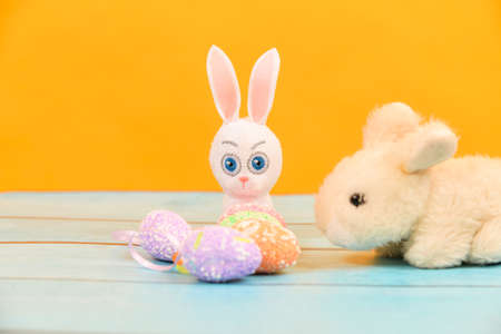 Easter toy bunny with painted eggs on a blue tree.の写真素材