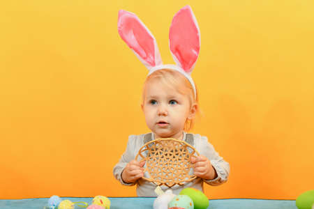 Little girl shows an empty basket for painted Easter eggs for the Easter holiday.