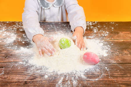 Little joyful girl in flour with Easter eggs.の写真素材