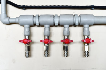 Four taps for water supply are fed into one system, fixed on the wall.の写真素材