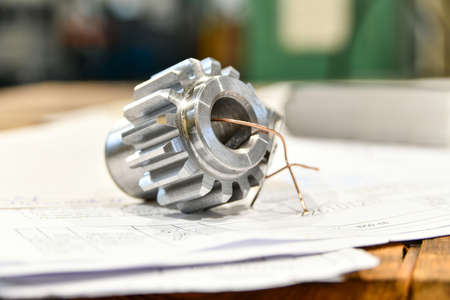 A cogwheel made on a gear cutting machine lies on the technical drawingsの写真素材