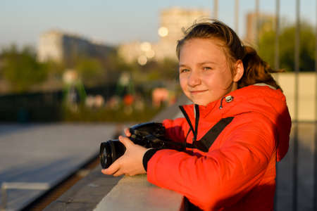 Portrait of a girl with a SLR camera in the city on the street.の写真素材