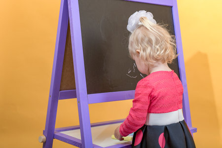 The child chooses crayons for drawing on the school board.の写真素材