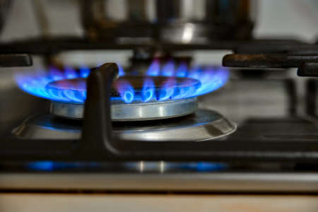 Gas cooking. The blue flames of the gas heat the food in the container.の写真素材