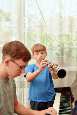 Two boys study at a music school and play the clarinet and piano.