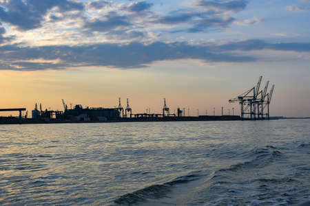 Cranes and industrial equipment in the sea, cargo port. View from the sea.の写真素材