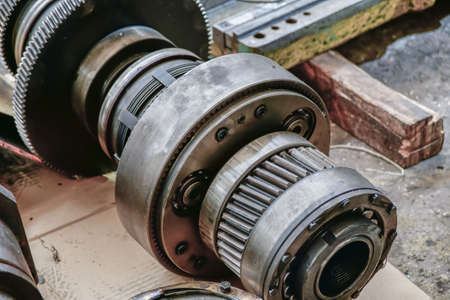 Disassembled gear wheels of a metalworking machine being repaired in a workshop.の写真素材