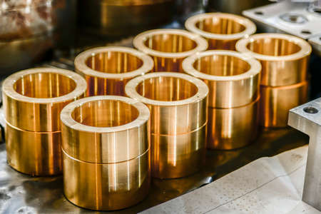Bronze bushings for plunger hydraulic pumps, made on a cnc lathe, stand on a rack in a warehouse.の写真素材