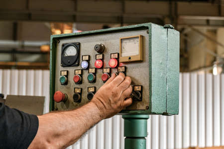 The worker adjusts the cutting conditions on a metalworking machine.の写真素材