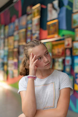 A girl in a museum of arts at an exhibition of painting against the backdrop of an art gallery.