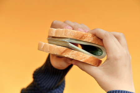 A man holds a sandwich made of money in his hands. Income, success and stability concept.