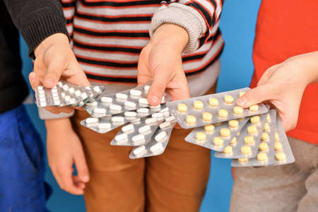 Children hold blisters with pills in their hands and offer them to those in need of medicines.