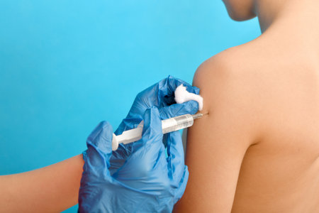 Vaccination of children, the doctor makes an injection in the shoulder of the child.