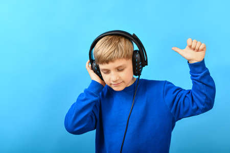 A boy with big headphones listens to music.の写真素材