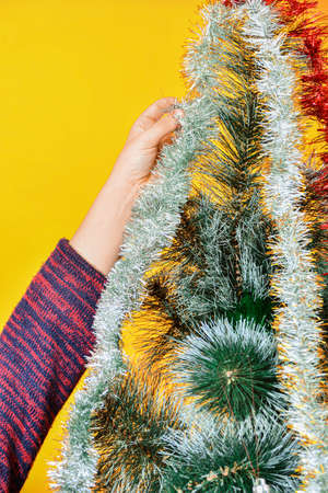 New Year's tinsel, showers and serpentines on the Christmas tree with festive toys.
