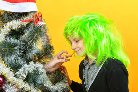 A boy shakes hands with a Christmas tree on the New Years holiday.