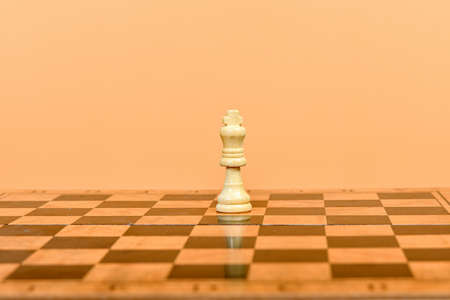 The white queen stands in the middle of the field on a chessboard.の写真素材