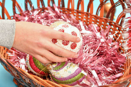 A girl arranges New Year's toys in a basket to decorate a Christmas tree.の写真素材