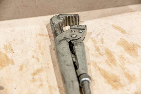 An adjustable gas wrench on a table in a locksmith's shop.