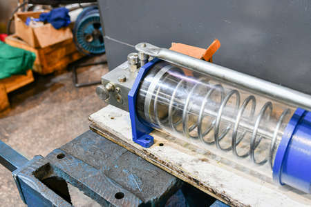 Hydraulic hand pump being repaired in a workshop.