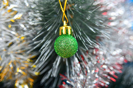 New Year's toy of green color on the background of the Christmas festive tree.の写真素材