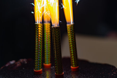 Burning candles-fireworks stand with a blazing fire in a festive cake.の写真素材