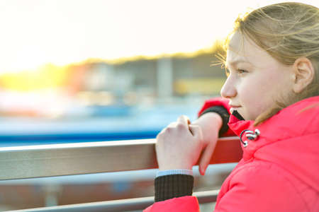 Portrait of a young girl on the bridge and looks away.