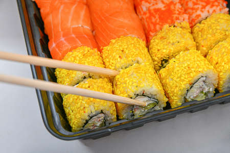 Bamboo sticks for sushi in a set. Various rolls, maki, nigiri in assortment in plastic packaging.の写真素材