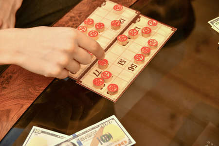 Lotto cards, chips and money lie on a glass coffee table. People play lotto for money.の写真素材