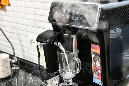 Preparing a cappuccino with milk in a coffee machine.