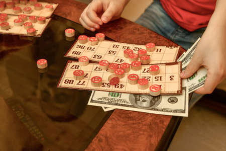 Children in the family circle play lotto for money. Brothers and sisters are having fun.の写真素材