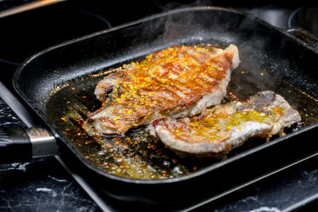 Fried meat in a pan with spices, cut into pieces.の写真素材