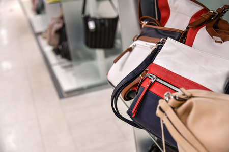Leather women's bags on the counter of a store in a mall.